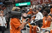 student filming at basketball game