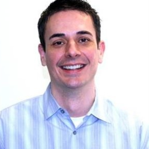 Man smiles at the camera for his headshot